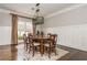Traditional dining room features hardwood floors, wainscoting, a modern light fixture, and an area rug at 275 Tynebrae Pl, Roswell, GA 30075