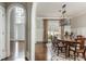 Charming dining room boasts wainscoting, hardwood floors, a modern light fixture, and is next to the entry foyer at 275 Tynebrae Pl, Roswell, GA 30075