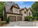 Elegant home with a three-car garage, manicured landscaping, and a grand entrance with a soaring window at 275 Tynebrae Pl, Roswell, GA 30075