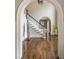 View of foyer and staircase boasts hardwood floors, staircase, archway to dining room, and a coat rack at 275 Tynebrae Pl, Roswell, GA 30075