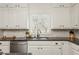 Well-lit kitchen features granite counters, tiled backsplash, stainless appliances, and ample cabinet storage at 275 Tynebrae Pl, Roswell, GA 30075