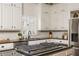 Beautiful kitchen featuring white cabinets, stainless steel appliances, an island cooktop, and granite counters at 275 Tynebrae Pl, Roswell, GA 30075