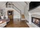 Cozy living room with a fireplace, hardwood floors, and staircase leading to the upper level at 275 Tynebrae Pl, Roswell, GA 30075