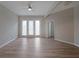 Open living room with neutral walls, wood-look floors and bright light from the three paneled balcony doors at 5300 Peachtree Rd. # 3107, Chamblee, GA 30341