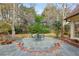 Outdoor patio area surrounded by a lush, landscaped backyard and mature trees at 540 Saint James Pl, Marietta, GA 30064