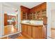 Wet bar with wood cabinets, sink, and storage; opens to an adjacent eat-in kitchen with wood floors at 540 Saint James Pl, Marietta, GA 30064