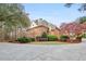 Side angle of a brick two-story home featuring a lush lawn, manicured landscaping, and circular driveway at 540 Saint James Pl, Marietta, GA 30064