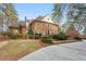 Side angle of a brick two-story home featuring a lush lawn, manicured landscaping, and circular driveway at 540 Saint James Pl, Marietta, GA 30064