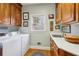 Well-lit laundry room with front loading washer and dryer, a window, and wood cabinets at 540 Saint James Pl, Marietta, GA 30064