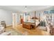 Spacious primary bedroom with hardwood floors, four-poster bed, and natural light from large windows at 540 Saint James Pl, Marietta, GA 30064