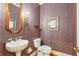 Charming powder room with patterned wallpaper, a pedestal sink, and decorative mirror at 540 Saint James Pl, Marietta, GA 30064