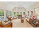 Sunroom with walls of windows, wicker furniture, and tile flooring at 540 Saint James Pl, Marietta, GA 30064