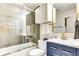 Bright bathroom featuring a shower-over-tub, stylish vanity with gold fixtures, and shiplap walls at 920 Memorial Se Dr # 35, Atlanta, GA 30316