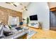 Spacious living room with exposed brick, hardwood floors, large sofa, and modern decor at 920 Memorial Se Dr # 35, Atlanta, GA 30316