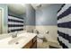 Bathroom with a blue striped shower curtain, cream walls, and vanity with chrome faucet at 1074 Whooping Creek Rd, Carrollton, GA 30116
