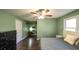 Bedroom with a ceiling fan, closet, window, dark wood flooring and neutral green walls at 1074 Whooping Creek Rd, Carrollton, GA 30116