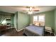 Cozy bedroom with dark wood floors, ceiling fan, and natural light from a large window at 1074 Whooping Creek Rd, Carrollton, GA 30116