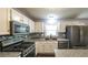 Charming kitchen features white cabinets, stainless appliances, granite countertops and backsplash at 1074 Whooping Creek Rd, Carrollton, GA 30116