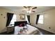 The bright main bedroom features dark wood floors, a ceiling fan, and two windows at 1074 Whooping Creek Rd, Carrollton, GA 30116