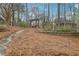 Backyard with a stone path leading to a swing, surrounded by lush greenery and pine straw at 1270 Smokehouse Trl, Cumming, GA 30041