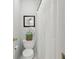 Cozy half-bath with a toilet, shower curtain, and an orchid above the toilet at 1270 Smokehouse Trl, Cumming, GA 30041