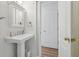 Charming bathroom featuring a pedestal sink, beadboard walls, and an open doorway at 1270 Smokehouse Trl, Cumming, GA 30041