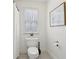 Neat bathroom featuring a toilet, window with blinds, and a shower with a white curtain at 1270 Smokehouse Trl, Cumming, GA 30041