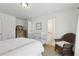 A cozy bedroom featuring a crib, wicker chair, and a glimpse into the en-suite bathroom at 1270 Smokehouse Trl, Cumming, GA 30041