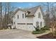 Exterior of a white home with a three-car garage and well-manicured landscaping at 1270 Smokehouse Trl, Cumming, GA 30041