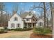 Charming two-story traditional home with stone accents, gabled roof, manicured lawn, and inviting front porch at 1270 Smokehouse Trl, Cumming, GA 30041