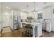 Bright kitchen with stainless steel appliances, white cabinetry, central island with seating, and hardwood floors at 1270 Smokehouse Trl, Cumming, GA 30041