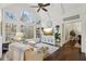 Bright and airy living room featuring vaulted ceiling, large windows with wooded views, hardwood floors, and stylish decor at 1270 Smokehouse Trl, Cumming, GA 30041