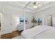 Light-filled primary bedroom featuring white walls, hardwood floors, dresser with TV, and minimalist decor at 1270 Smokehouse Trl, Cumming, GA 30041