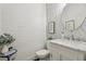 Charming powder room featuring a white brick wall, pedestal sink with granite countertop, and floral wallpaper at 1270 Smokehouse Trl, Cumming, GA 30041