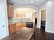 Modern kitchen with granite counters, wood cabinets, a stainless steel dishwasher, and dark wood floors at 2675 Sardis Chase Ct, Buford, GA 30519