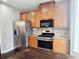 Kitchen features stainless steel appliances, wood cabinets, and stylish backsplash at 2675 Sardis Chase Ct, Buford, GA 30519