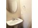 Bright half bathroom with stylish oval mirror and pedestal sink at 2675 Sardis Chase Ct, Buford, GA 30519