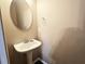 Bright half bathroom with stylish oval mirror and pedestal sink at 2675 Sardis Chase Ct, Buford, GA 30519