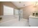 Bright bathroom features a soaking tub, glass enclosed shower and dual vanities at 4015 Embassy Way, Lilburn, GA 30047