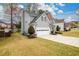 Side view of home, showing well-maintained lawn, two-car garage, and mature trees at 4015 Embassy Way, Lilburn, GA 30047