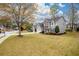 Spacious front lawn with view of two-story home featuring gray siding and brick accents at 4015 Embassy Way, Lilburn, GA 30047