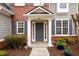 Inviting entryway with gray front door, brick accents, white pillars and manicured landscaping at 4015 Embassy Way, Lilburn, GA 30047