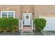 Close-up of front door of a brick home with white trim, bushes, and a wreath at 2160 Liberty Hts, Fairburn, GA 30213
