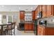 An eat-in kitchen with granite countertops, dark wood cabinetry, stainless appliances, and sliding glass doors at 2160 Liberty Hts, Fairburn, GA 30213
