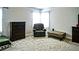 A cozy bedroom featuring an accent chair, dresser, and a large window at 3489 Central Park Dr, Loganville, GA 30052
