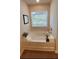 Bathroom featuring a deep soaking tub under a window, with white towels and decor at 4276 Notting Hill Dr # 23, Atlanta, GA 30331