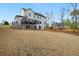 Large backyard with a view of the home's deck and a backdrop of mature trees on a sunny day at 4980 Wildeoak Trl, Douglasville, GA 30135