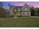 Beautiful home with a well-manicured lawn and stone accents at dusk, offering curb appeal and charm at 4980 Wildeoak Trl, Douglasville, GA 30135
