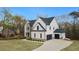 Stunning new home boasts a three-car garage, well-manicured lawn, and white painted brick exterior at 4980 Wildeoak Trl, Douglasville, GA 30135