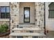 Stylish front entryway features stone accents, a modern glass door, and bluestone steps at 4980 Wildeoak Trl, Douglasville, GA 30135